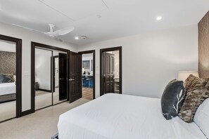 A bedroom with a large bed, a ceiling fan, and a bathroom visible through an open door. - 421 Beaver Creek Lodge at the Covered Bridge, Pool, Hot Tub, Gym, Steam Room (Beaver Creek)