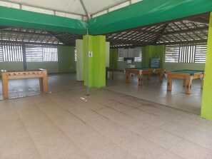 A room with a pool table, a green partition, and a tiled floor. - Refugio Natureza e Praia 4 quartos (Camaçari)