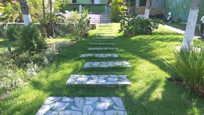 Un sentier de jardin, avec des pas japonais, qui mène à un bâtiment.
