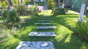 Un sendero de jardín con piedras para pisar que lleva a un edificio.