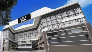 A modern building with a black and white facade, a prominent sign reading 'Collection Company-Serviced', and a patterned design on the side. - Collection O Vesu Surat (Surat)