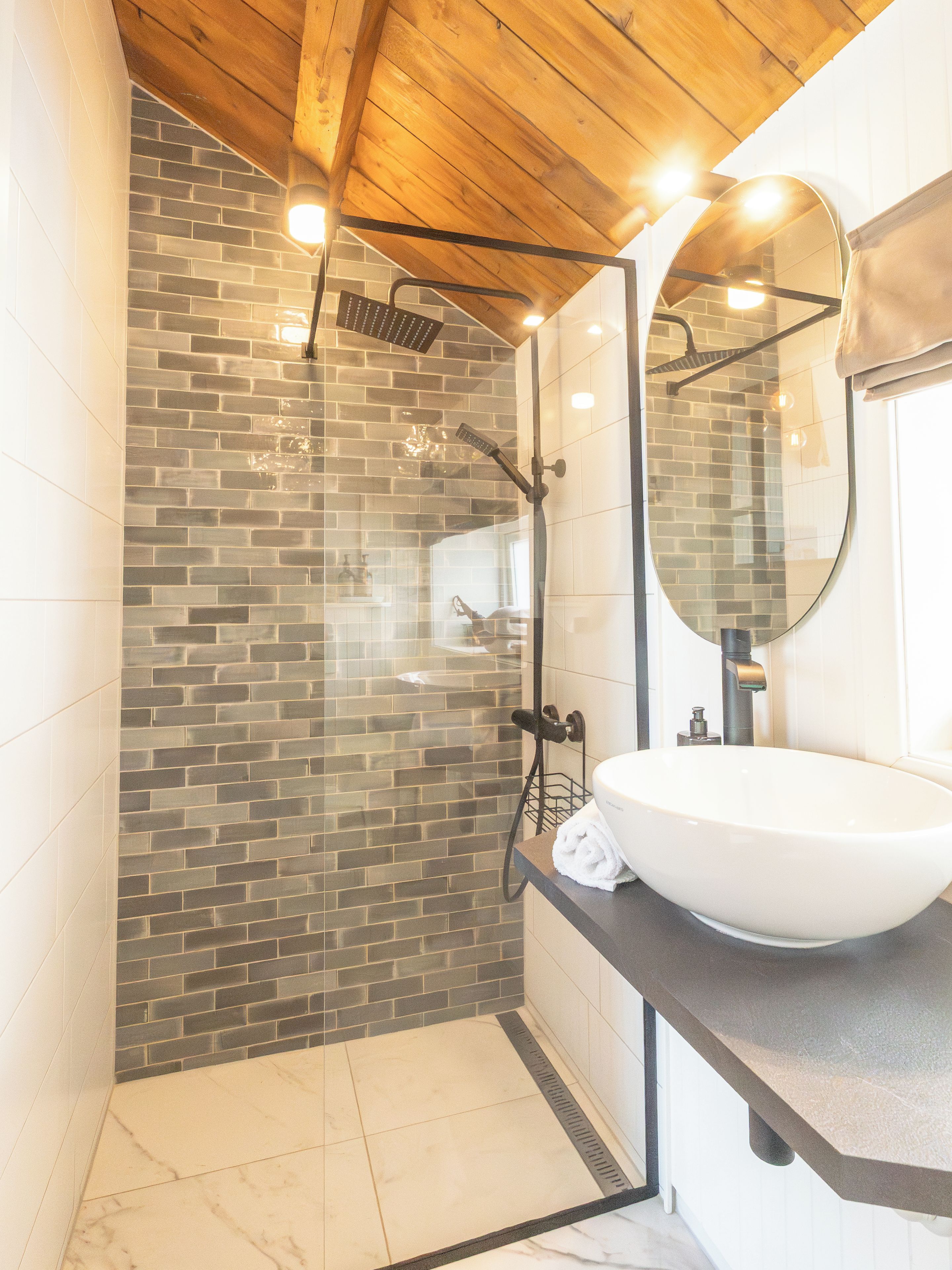 Ein Badezimmer mit Dusche, Waschbecken und Spiegel.