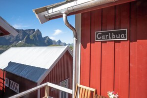 Un edificio rojo con un letrero que dice 'Carlbua' y una vista de montañas al fondo.