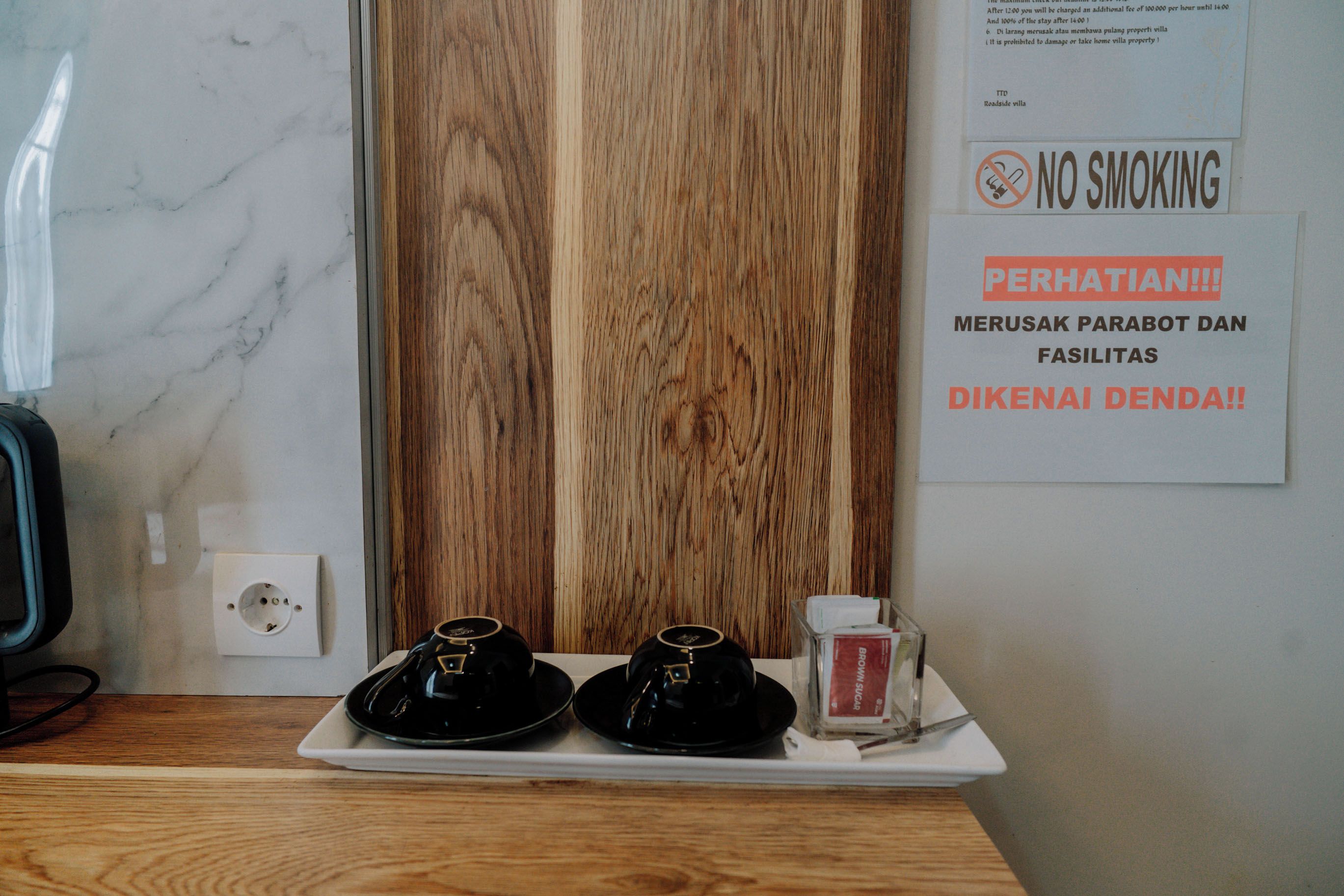 A hotel room with a wooden panel wall, a white marble countertop, and a sign indicating no smoking.