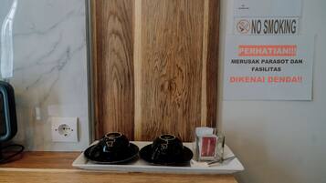 A hotel room with a wooden panel wall, a white marble countertop, and a sign indicating no smoking.