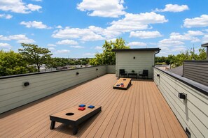 Eine Dachterrasse mit Schachtelhalm-Tisch, zwei Stühlen und einem kleinen Tisch mit einer Pflanze.