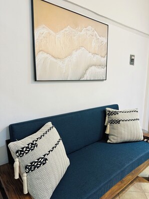 A blue sofa with patterned cushions against a white wall, with a framed artwork above. - Affordable 1 Bedroom with Amazing Rooftop Terrace - Great Bucerias Location (Bucerías)