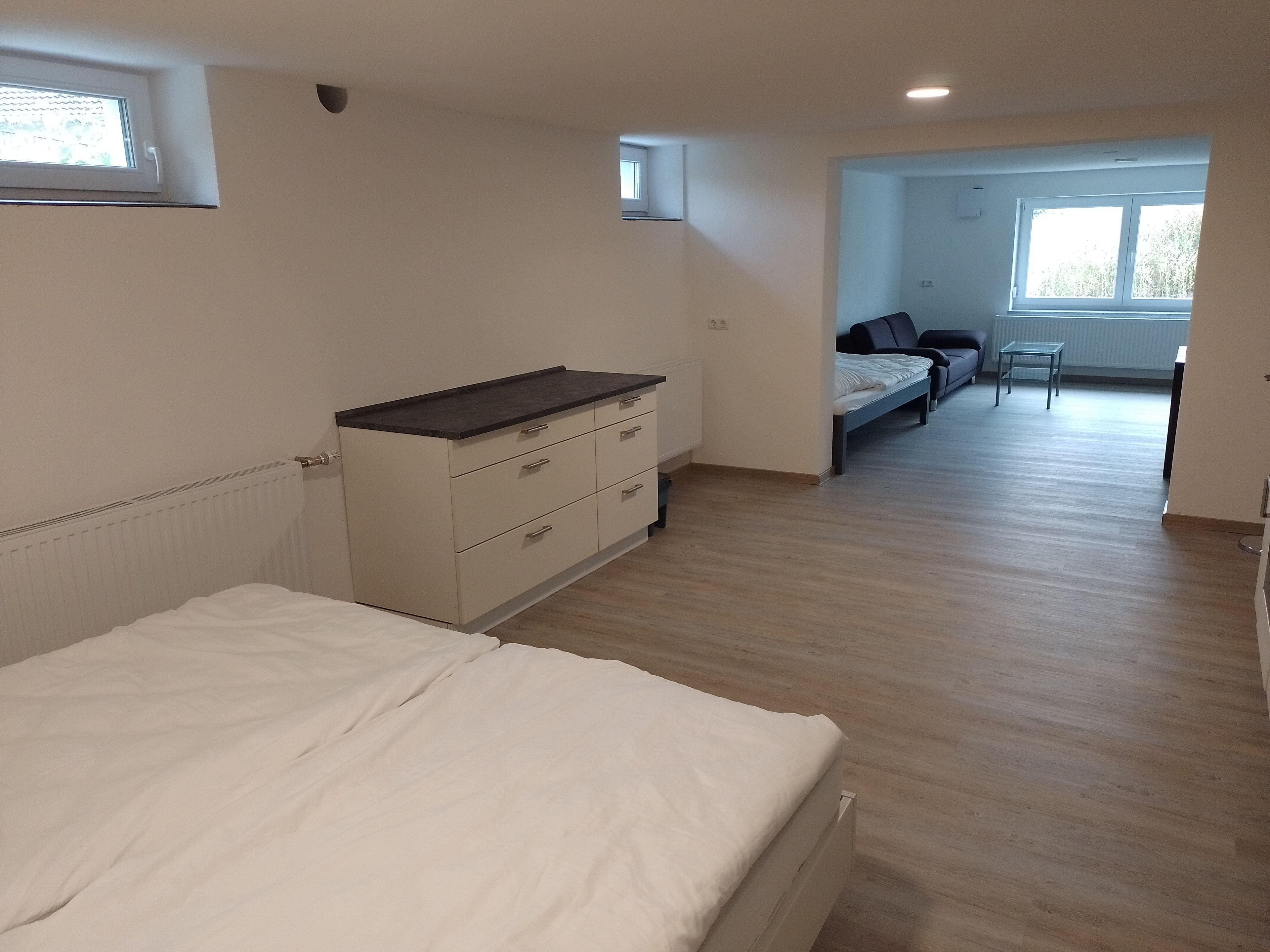 Ein Schlafzimmer mit einem Bett, einem Schminktisch und einem Fenster.