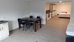 Un apartamento moderno con comedor, kitchenette y un dormitorio.