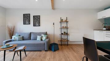 A modern living room with a grey sofa, a coffee table, and a bookshelf.