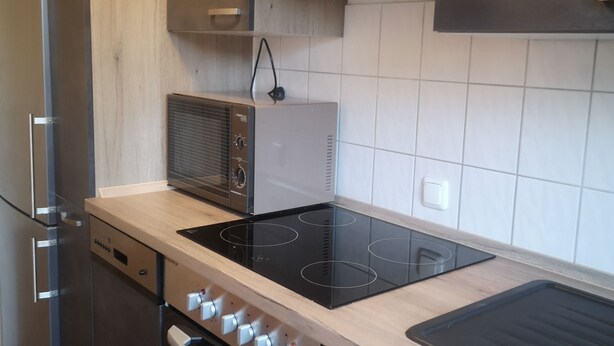 Una cocina moderna con electrodomésticos de acero inoxidable, horno empotrado y microondas.