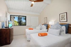 A room with two beds, a wooden dresser, a ceiling fan, a window with shutters, and framed artwork on the wall. - Napili Point | 2 Oceanfront Villas, Sleeps 8 | Car Incl. w/ 6+ Nights | ML-4346 by KBM (Lahaina)