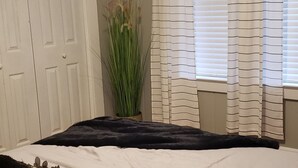A bedroom with a bed, a potted plant, and curtains. - Three Rivers Retreat (Lake City)