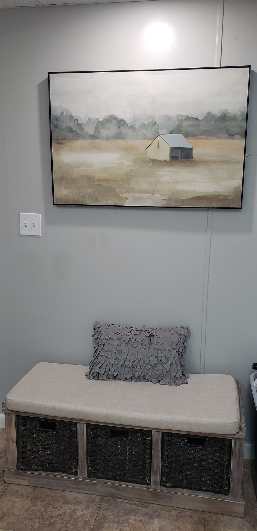 Ein Zimmer mit einer Sitzbank, einem Landschaftsbild und einer Steckdose.