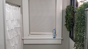 A compact bathroom with a toilet, sink, and window. - Three Rivers Retreat (Lake City)