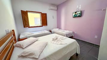 Habitación de hotel con dos camas, televisión y ventana con persianas.
