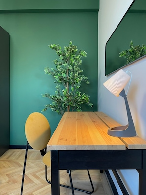 A room with a wooden table, a yellow chair, a green wall, and a mirror. - Chill Flow Calea Victoriei next to The Old Town (București)