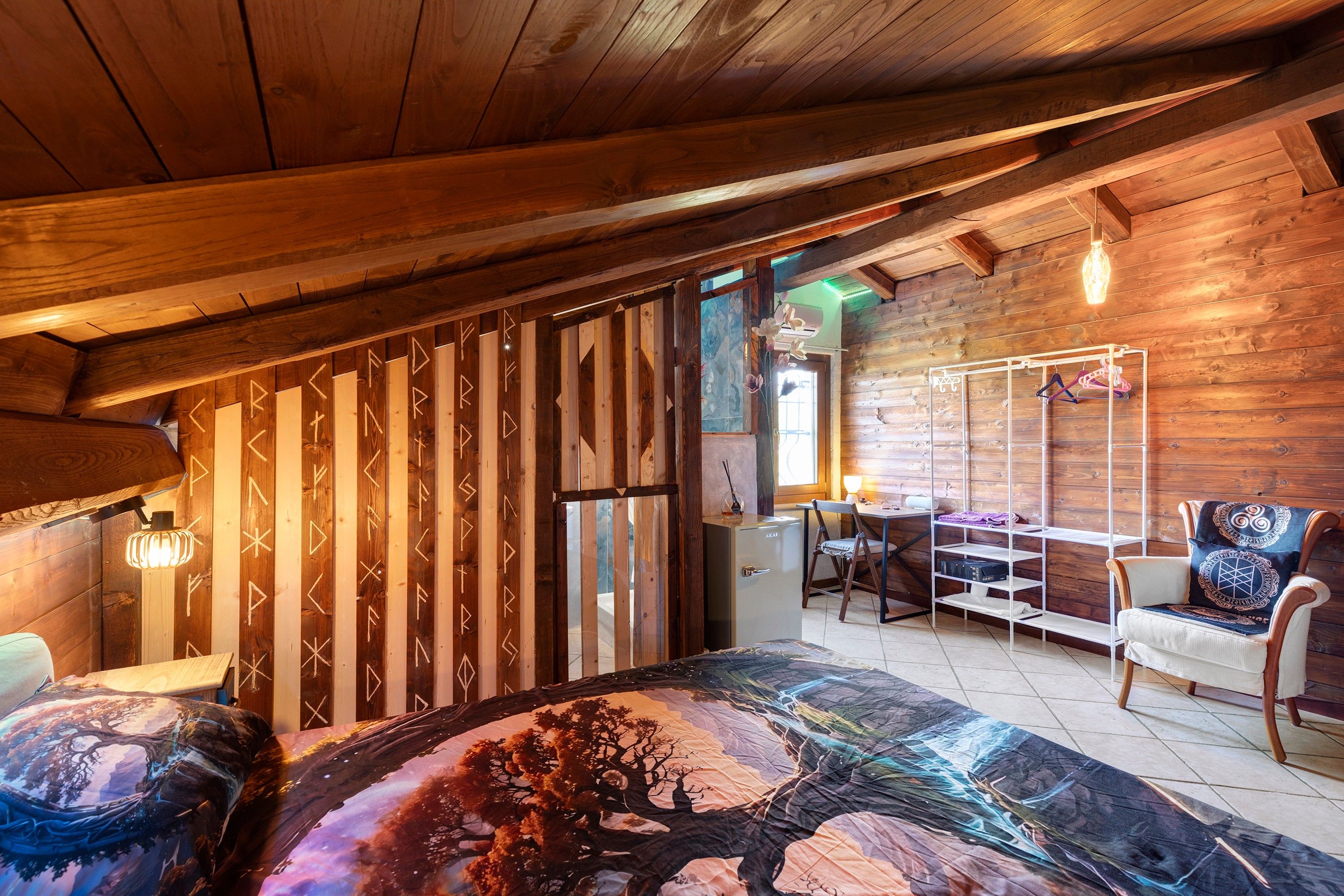 Ein Zimmer mit Holzeinrichtung, einem Bett, einem Schreibtisch und einem Stuhl.