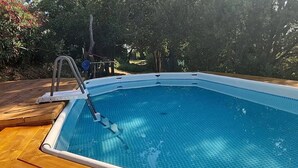 A rectangular swimming pool with a ladder on one side, surrounded by a wooden deck. - Room 'Dea' with Shared Pool, Wi-Fi and Air Conditioning (Santa Marinella)