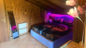 A bedroom with a bed, a mirror, and a wooden ceiling. - Room 'Dea' with Shared Pool, Wi-Fi and Air Conditioning (Santa Marinella)