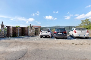 Three cars parked in a lot with a stone gate and a sign that reads 'Land of Freedom'.