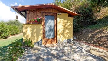 Ein kleines, eingeschossiges Gebäude mit einer Holztür und einer kleinen Veranda.