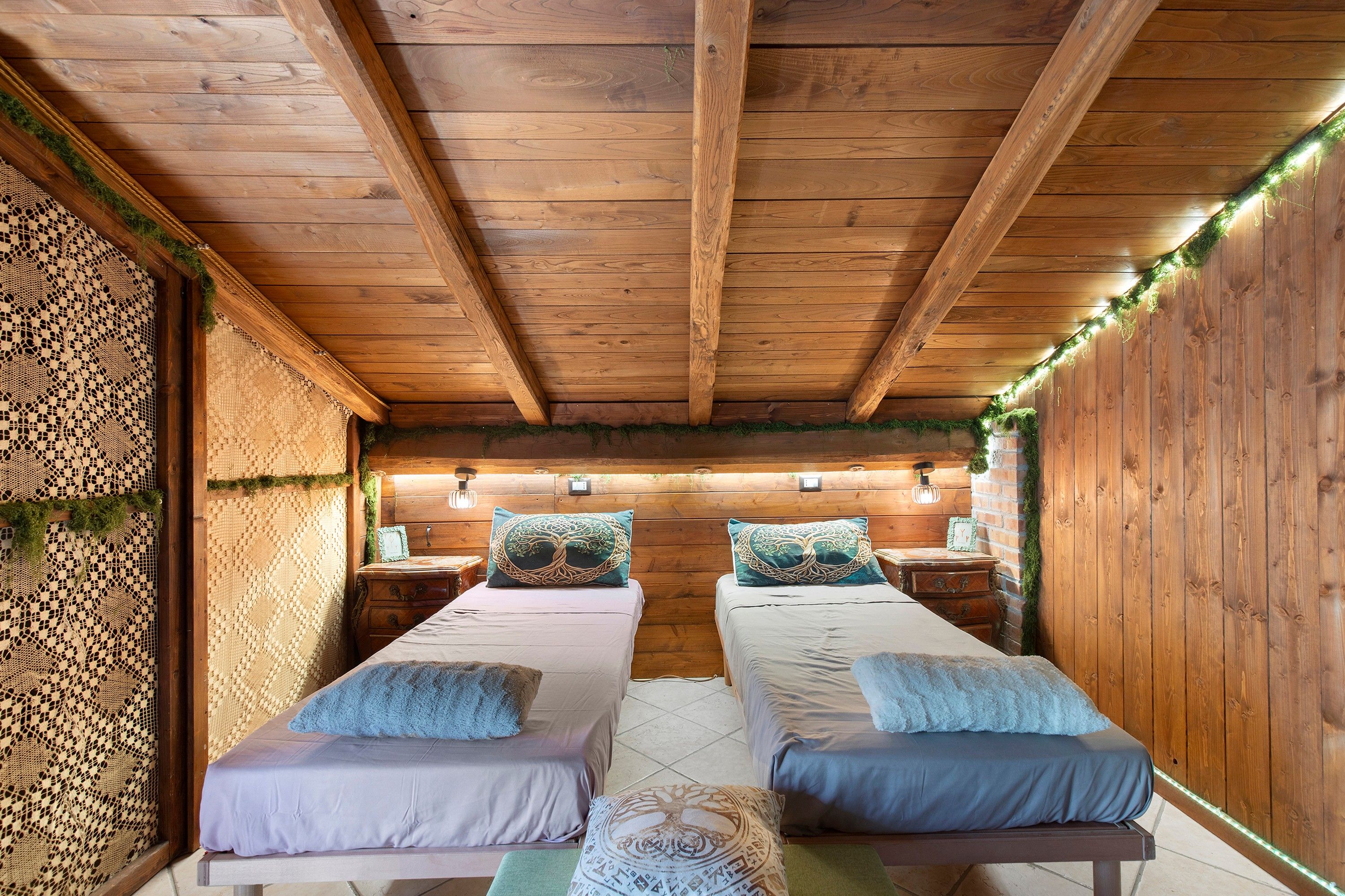 Ein gemütliches Zimmer mit zwei hölzernen Betten, einer gewobenen Wand und einer rustikalen Decke.