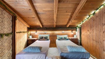 Ein gemütliches Zimmer mit zwei hölzernen Betten, einer gewobenen Wand und einer rustikalen Decke.