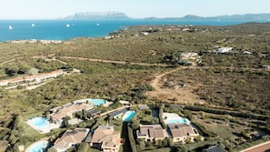 Um imóvel costeiro com vários edifícios, piscinas e vista para o mar.