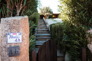 A stone pillar with a sign reading 'Rosella 4B' and a wooden gate. - Villetta Rosella by Wonderful Italy (Golfo Aranci)
