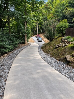 A curved driveway leading to a vehicle parked at the end.