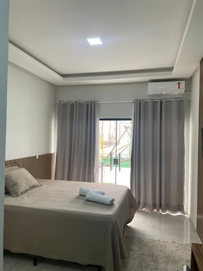 A bedroom with a bed, curtains, an air conditioning unit, and a view of the outside. - HOTEL PÉ DE SERRA  (Piranhas)