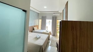 Ett hotellrum med två sängar, ett skrivbord och utsikt över omgivningarna.