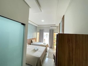 A hotel room with two beds, a desk, and a view of the outdoors. - HOTEL PÉ DE SERRA  (Piranhas)