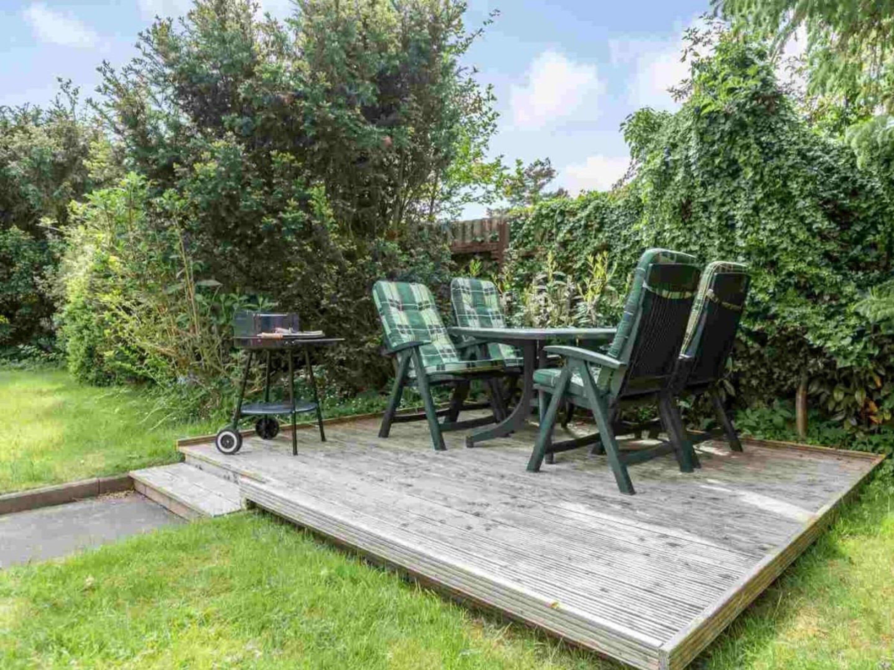 A deck with outdoor furniture, a table, and chairs.