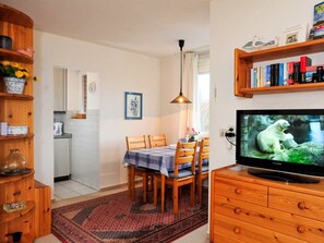 Un salon confortable avec un téléviseur, des meubles en bois et une bibliothèque.