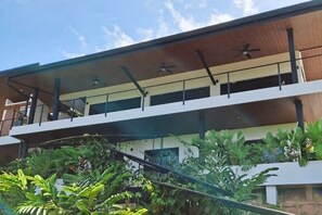 Un edifici amb diversos pisos, balcons i una zona exterior coberta.