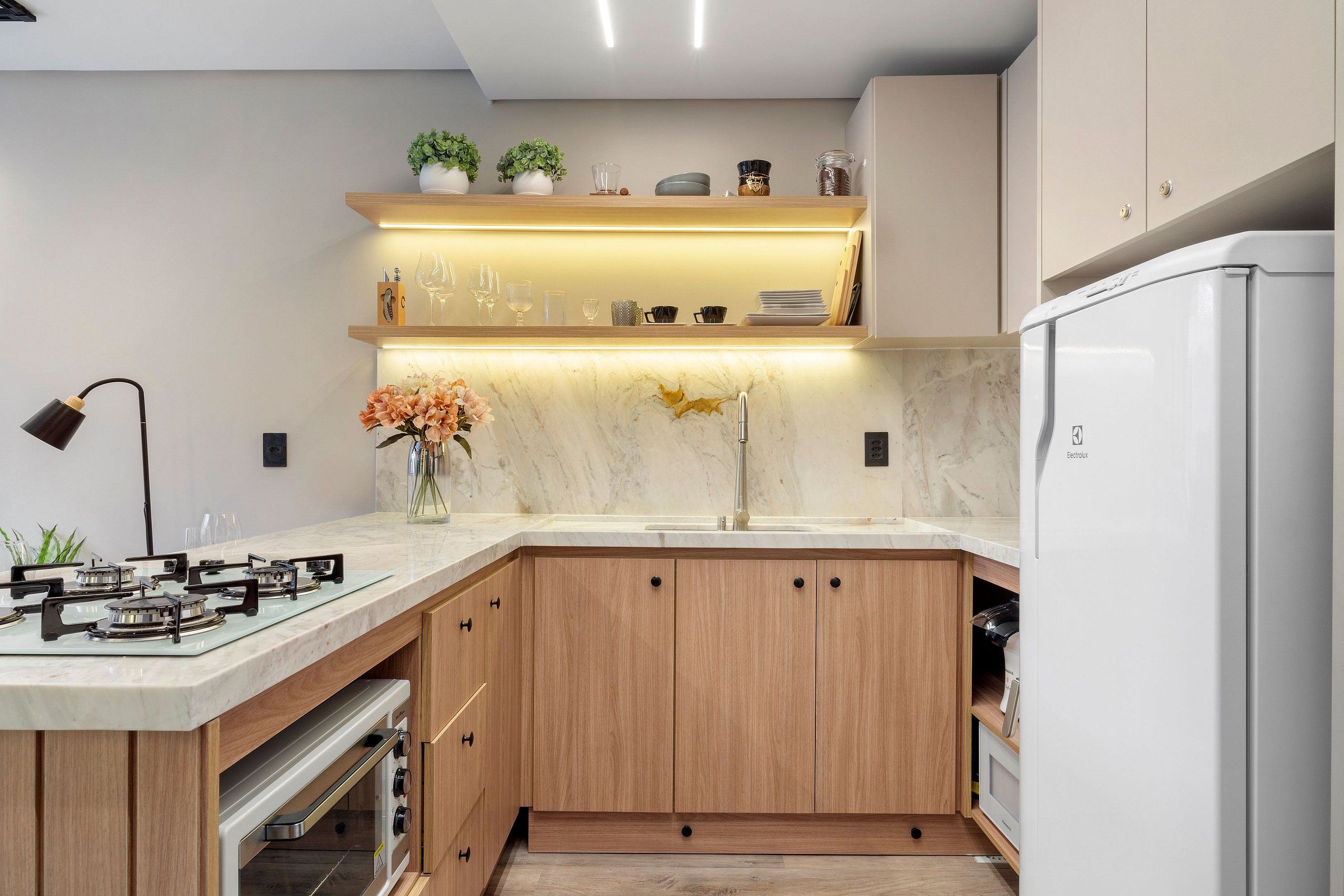 Una cocina moderna con estufa a gas, horno empotrado, pileta y refrigerador.