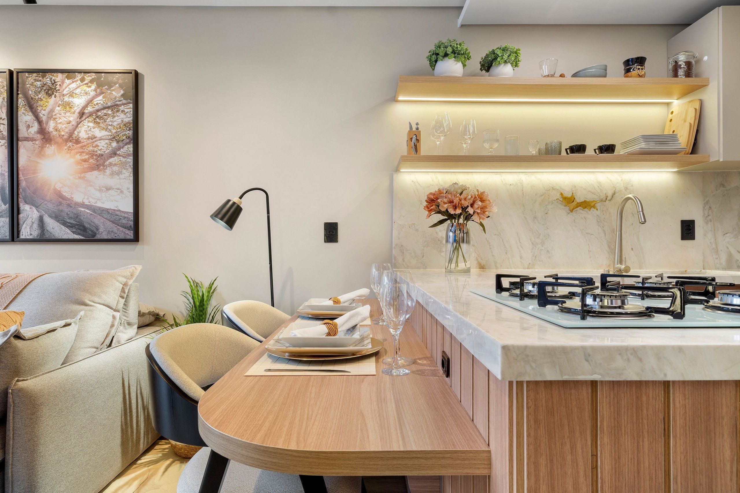 Een moderne keuken met een centraal eiland, inbouwapparatuur en een eethoek met een ronde tafel en stoelen.