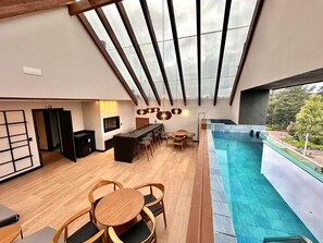 Un interior moderno con comedor, cocina y piscina.