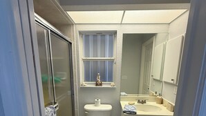 Et badeværelse med toilet, vask og bruser.