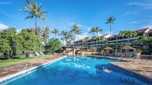 A swimming pool with lounge chairs, palm trees, and a hotel building in the background. - Kaanapali Royal | 3 Ocean View Villas, Sleeps 17 | Car Incl. w/ 6+ Nights | ML-4688 by KBM (Lahaina)