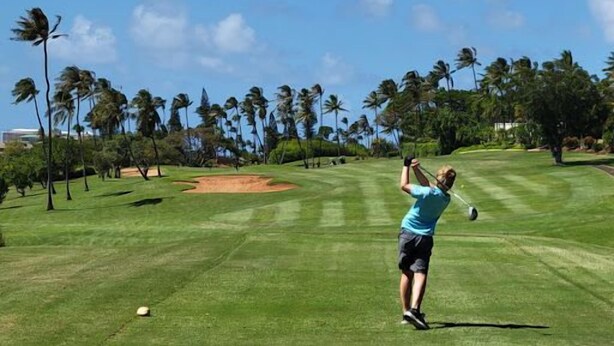 A golf course with a clear sky, palm trees, and a golfer in mid-swing. - Kaanapali Royal | 3 Ocean View Villas, Sleeps 17 | Car Incl. w/ 6+ Nights | ML-4688 by KBM (Lahaina)