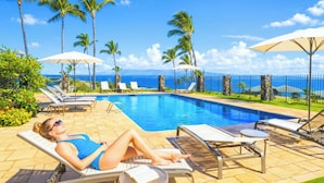 A poolside area with lounge chairs, umbrellas, and a view of the ocean. - Kapalua Bay Villas | 2 Oceanfront Villas, Sleeps 12 | Car Incl. w/ 6+ Nights | ML-4691 by KBM (Lahaina)