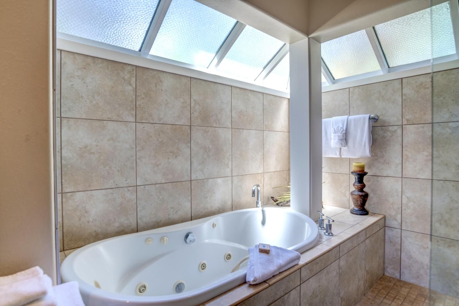 Een moderne badkamer met een vrijstaand bad, een wastafel met spiegel en een handdoekrek.