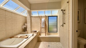 A modern bathroom with a bathtub, shower, and toilet. There are skylights providing natural light. - Kapalua Bay Villas | 3 Oceanfront Villas, Sleeps 16 | Car Incl. w/ 6+ Nights | ML-4694 by KBM (Lahaina)