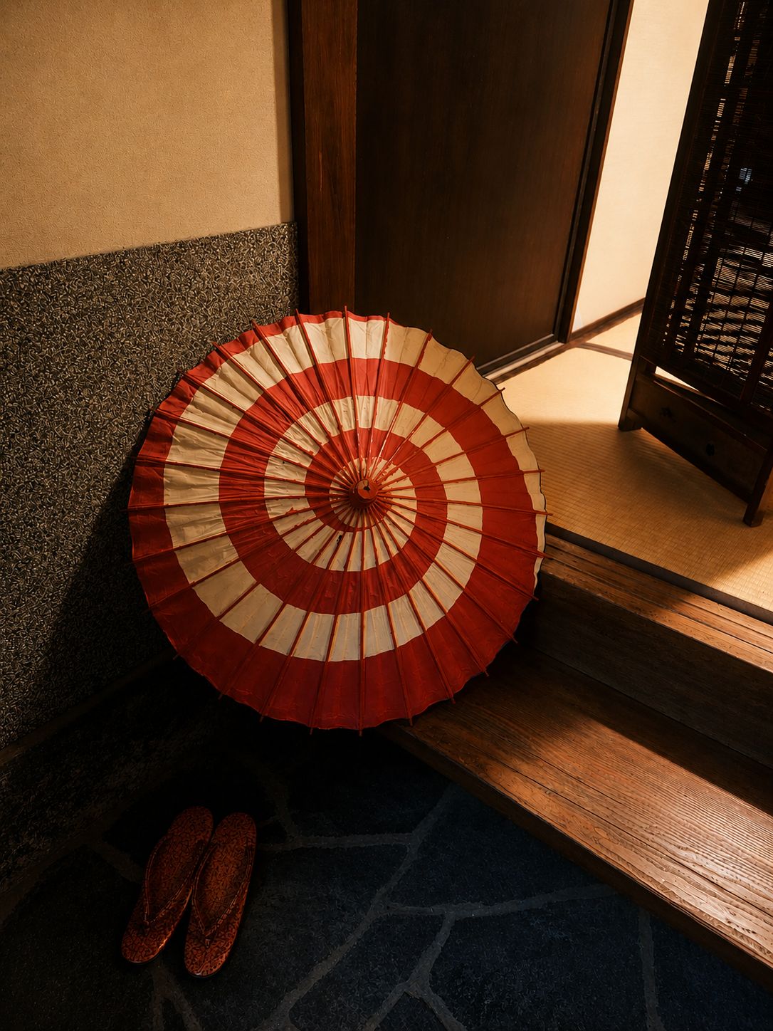 Ett traditionellt japanskt rum med tatamimattor på golvet, en trädörr och en röd- och vitrandig fläkt.