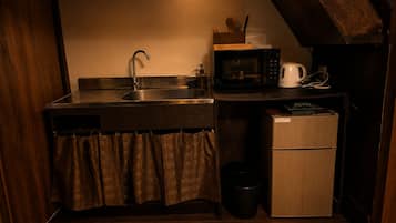 Et lille køkken med vask, mikroovn, kaffemaskine og et minikøleskab.