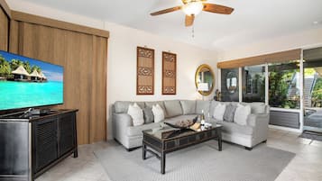 A living room with a sofa, coffee table, TV, and decorative items.