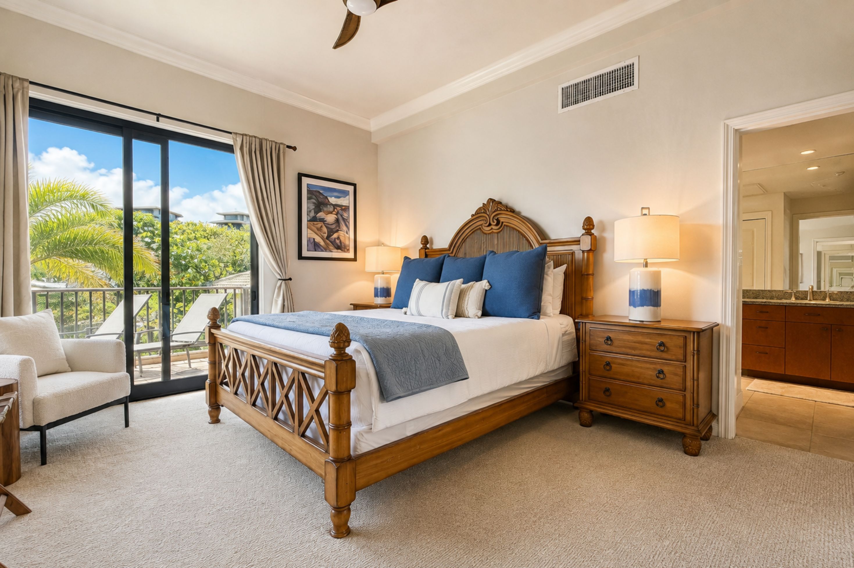 A bedroom with a large bed, a nightstand, a dresser, and a view of the outdoors.